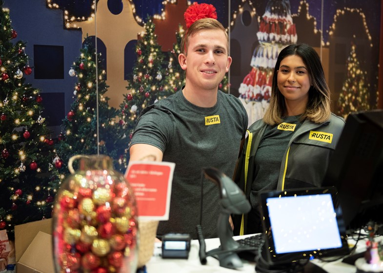 a man and woman standing next to a laptop