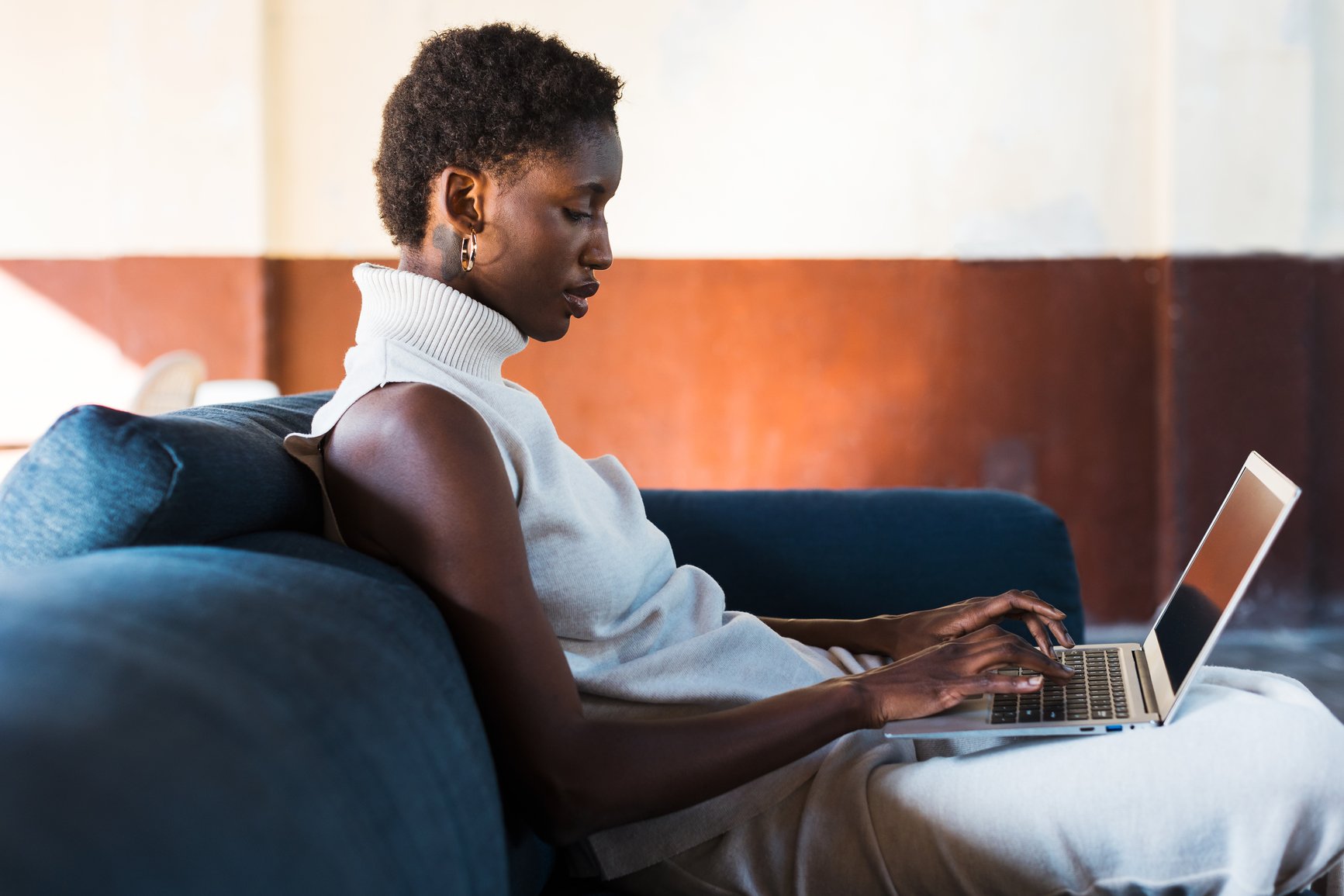 a man sitting on a couch using a laptop