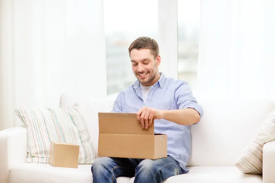a man sitting on a couch holding a box