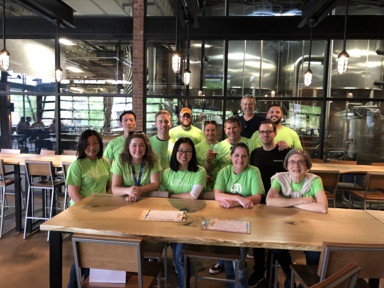 a group of people in green shirts sitting at a table