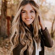 a woman smiling with her hand on her head