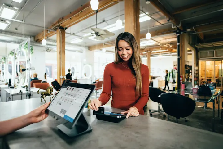 Person checking out at cash register with credit card