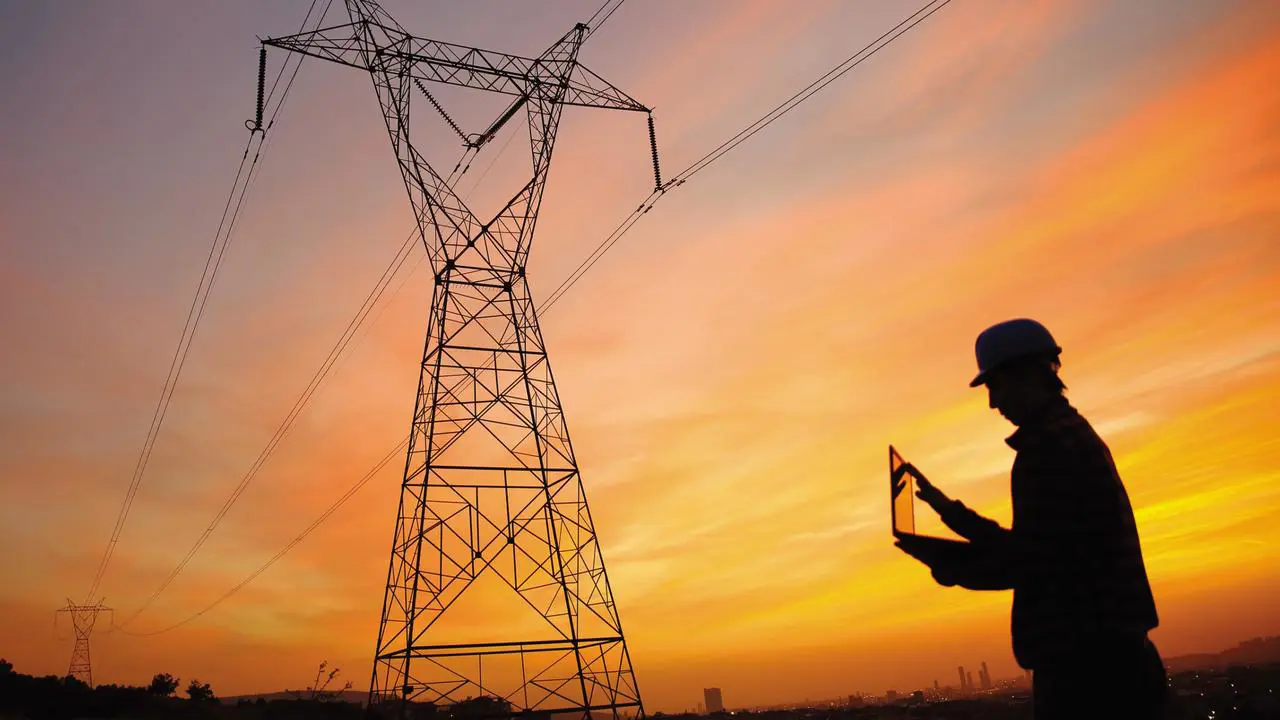Man near electrical equipment at sunset