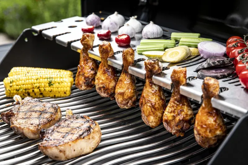 Chicken drumsticks being cooked on grill