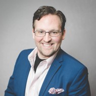 a man wearing glasses and a suit