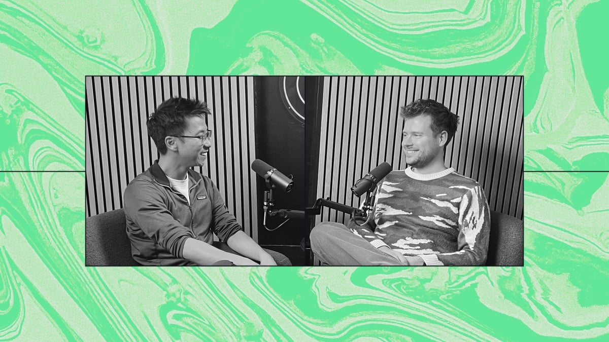 a couple of men sitting on a couch with a microphone