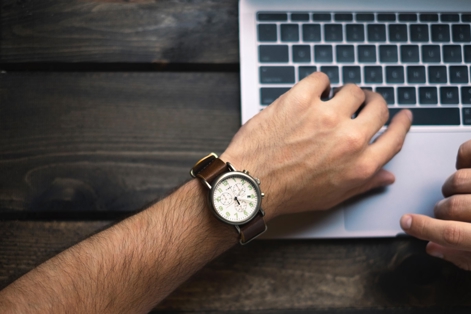 a man's hands holding a watch
