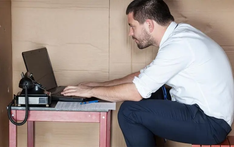 a man sitting at a desk with a laptop