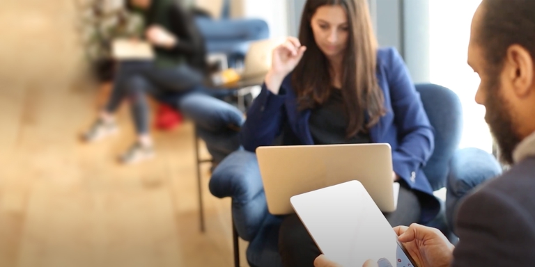 a man and a woman using laptops