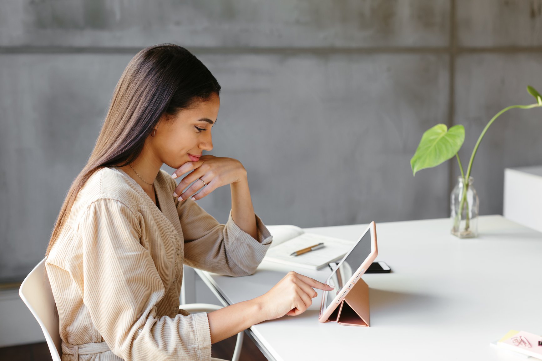 a woman sitting at a table looking at a book